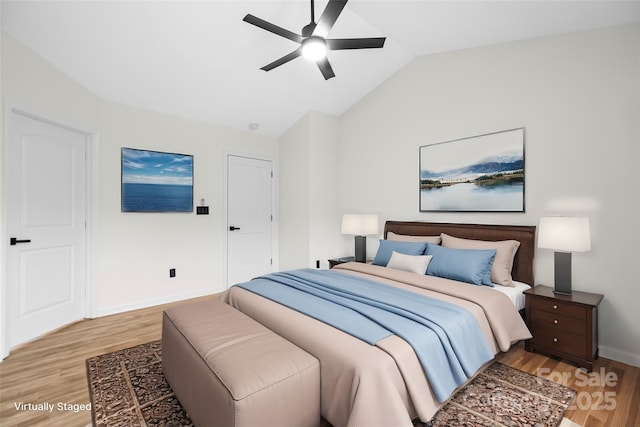 bedroom featuring light wood-style flooring, ceiling fan, baseboards, and vaulted ceiling