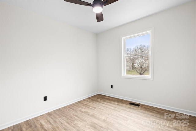 spare room with light wood-type flooring, baseboards, visible vents, and a ceiling fan