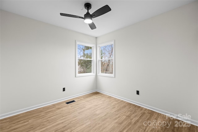 spare room featuring visible vents, baseboards, light wood-style floors, and a ceiling fan