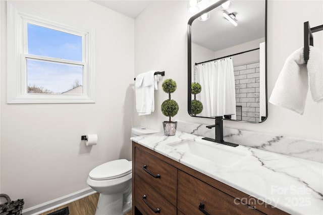 full bathroom with a shower with curtain, toilet, wood finished floors, baseboards, and vanity