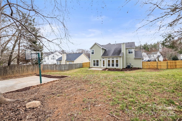 rear view of property with a yard, a fenced backyard, and a patio