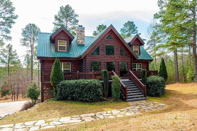 log home featuring a chimney, metal roof, stairway, and a wooden deck