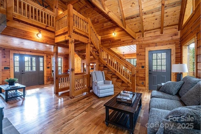 living area with plenty of natural light, wood ceiling, and wooden walls