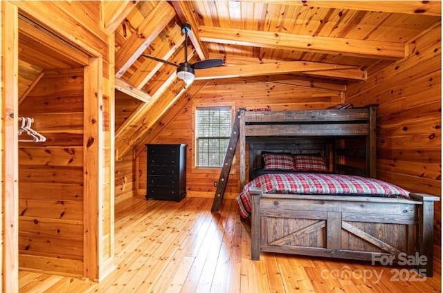 unfurnished bedroom featuring lofted ceiling with beams, wood walls, wooden ceiling, and hardwood / wood-style flooring