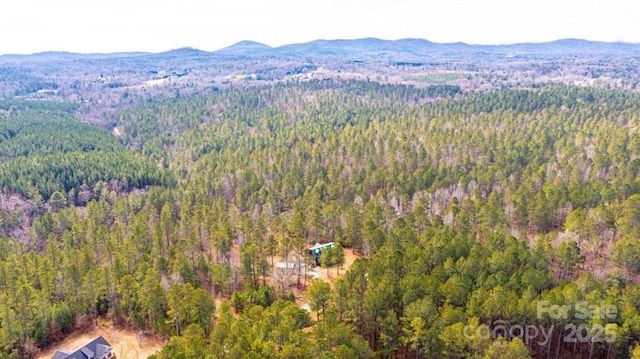 aerial view with a mountain view and a wooded view