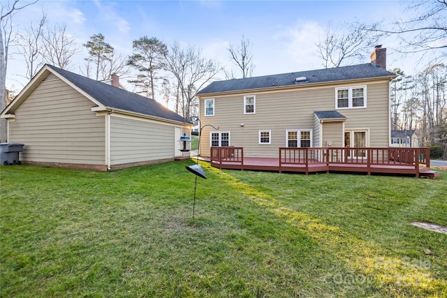 back of property with a yard, a chimney, and a wooden deck