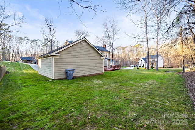 view of side of home featuring a chimney, a deck, and a yard