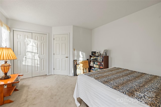 carpeted bedroom with a closet and a textured ceiling