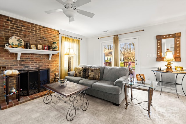 living room with ceiling fan, a fireplace, visible vents, and crown molding