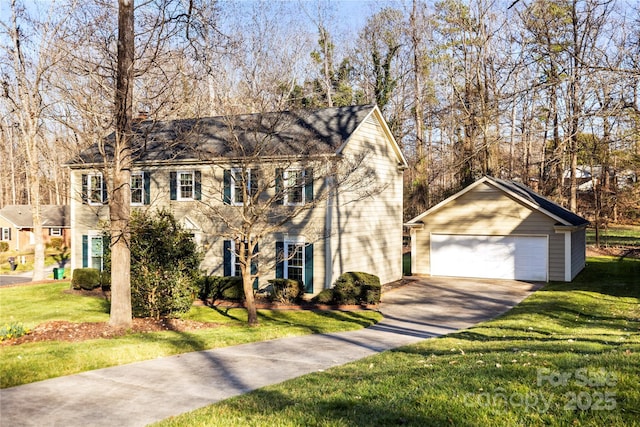 colonial home with an outbuilding, a front yard, and a detached garage