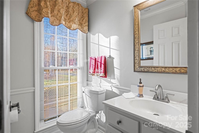 half bath featuring toilet, crown molding, and vanity