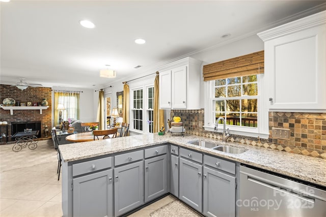 kitchen featuring dishwasher, a peninsula, a sink, and gray cabinetry