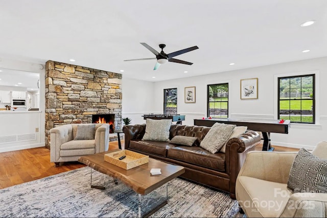 living room featuring recessed lighting, a fireplace, a ceiling fan, and wood finished floors