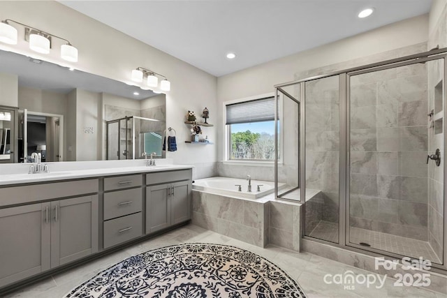 bathroom with a garden tub, double vanity, a sink, and a shower stall