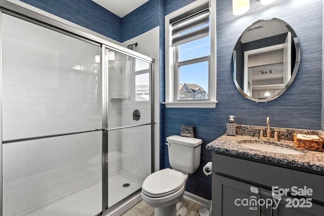 bathroom with vanity, a shower stall, and toilet