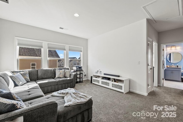 living area with carpet, visible vents, attic access, and baseboards