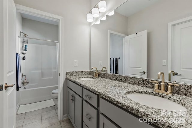 bathroom featuring double vanity, tile patterned flooring, a sink, and toilet