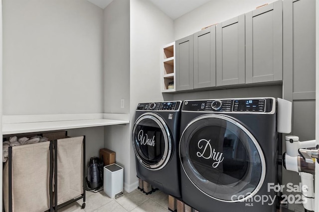 washroom with cabinet space, tile patterned flooring, and washer and dryer