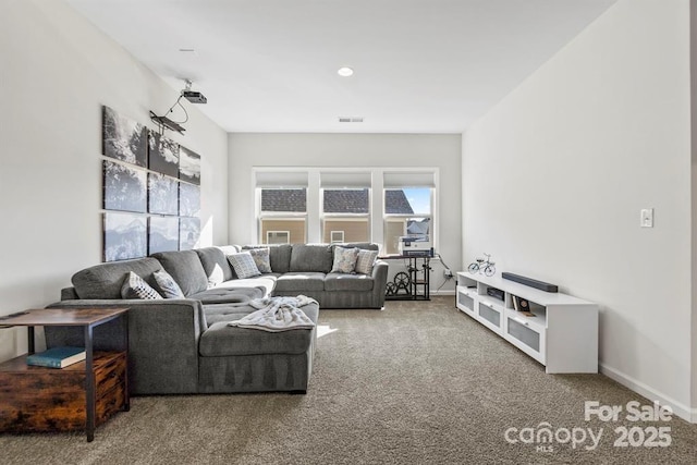 carpeted living area featuring baseboards and visible vents