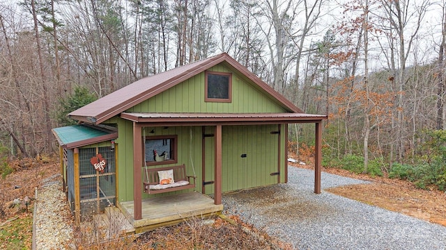 view of outdoor structure featuring an outbuilding and a forest view