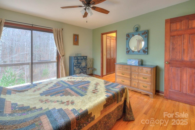 bedroom featuring a ceiling fan, baseboards, and light wood finished floors