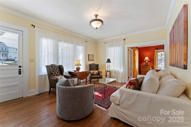 living room with ornamental molding, baseboards, and wood finished floors