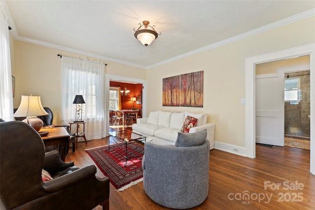 living room featuring baseboards, ornamental molding, and wood finished floors