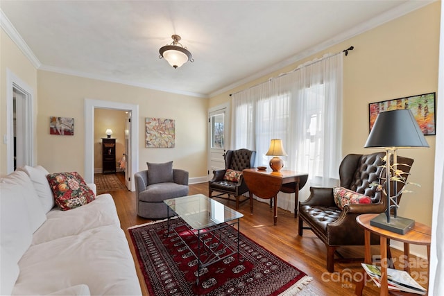 living area with baseboards, wood finished floors, and crown molding