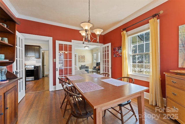 dining space featuring a notable chandelier, dark wood-style flooring, baseboards, french doors, and ornamental molding