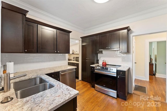 kitchen with appliances with stainless steel finishes, visible vents, a sink, and light wood finished floors