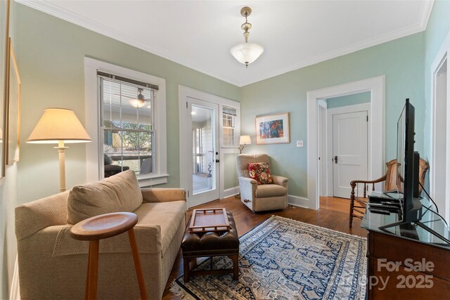 living area featuring baseboards, ornamental molding, wood finished floors, and french doors