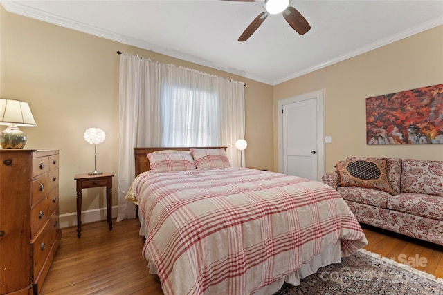 bedroom featuring ornamental molding, wood-type flooring, ceiling fan, and baseboards