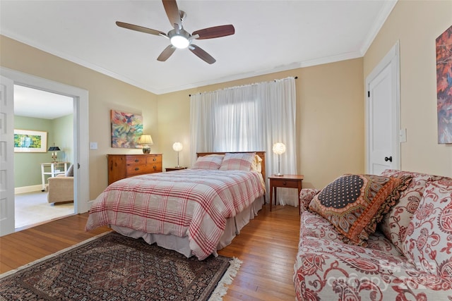 bedroom with wood-type flooring, ornamental molding, and ceiling fan