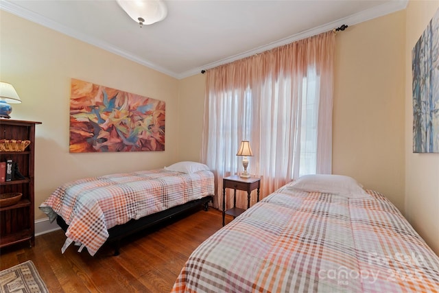 bedroom featuring crown molding, baseboards, and wood finished floors