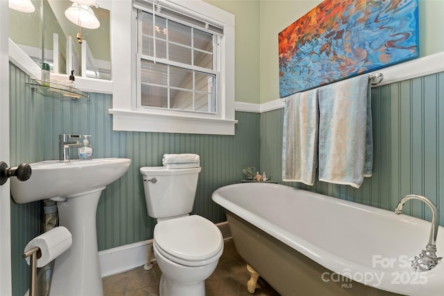 full bath with toilet, tile patterned flooring, and a freestanding bath