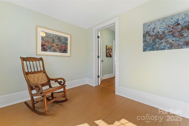 sitting room with baseboards and hardwood / wood-style floors