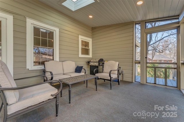 sunroom with a skylight and wooden ceiling