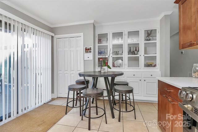 dining room featuring crown molding and light tile patterned floors