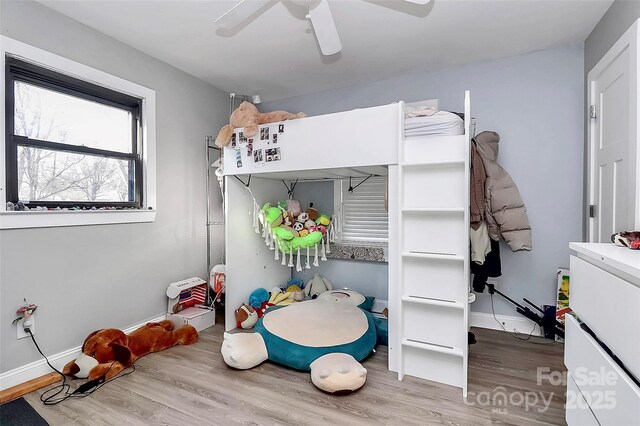 bedroom with a ceiling fan, baseboards, and wood finished floors