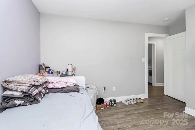 bedroom with baseboards and wood finished floors