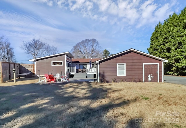 back of property with fence and a patio