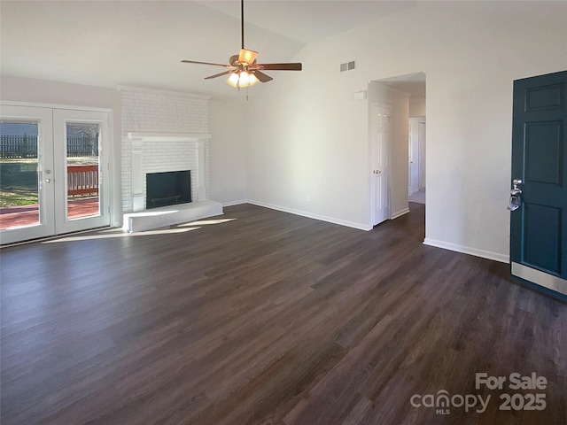 unfurnished living room with a brick fireplace, visible vents, vaulted ceiling, and dark wood-type flooring