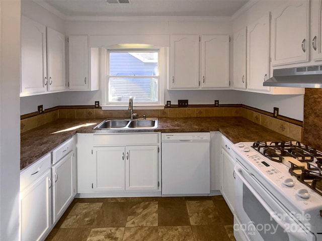 kitchen with dark countertops, white cabinetry, a sink, white appliances, and under cabinet range hood