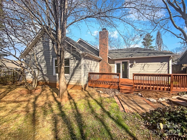 rear view of house featuring a chimney and a wooden deck