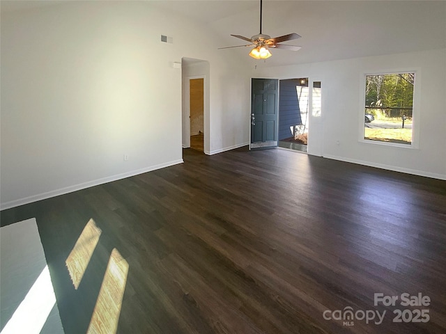 unfurnished room with ceiling fan, baseboards, visible vents, and dark wood finished floors