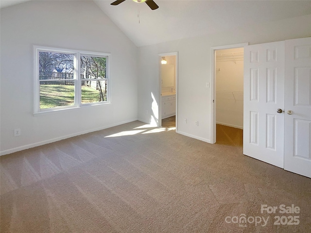 unfurnished bedroom featuring carpet floors, a walk in closet, a closet, connected bathroom, and baseboards