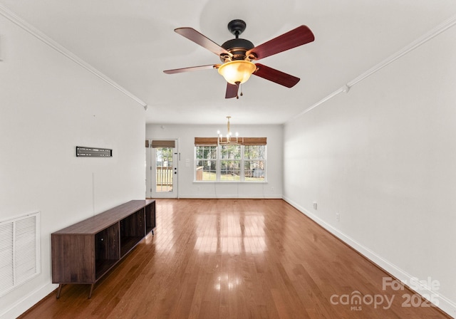 unfurnished living room with ornamental molding, visible vents, baseboards, and wood finished floors