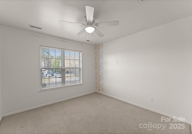 spare room with a ceiling fan, carpet, visible vents, and baseboards