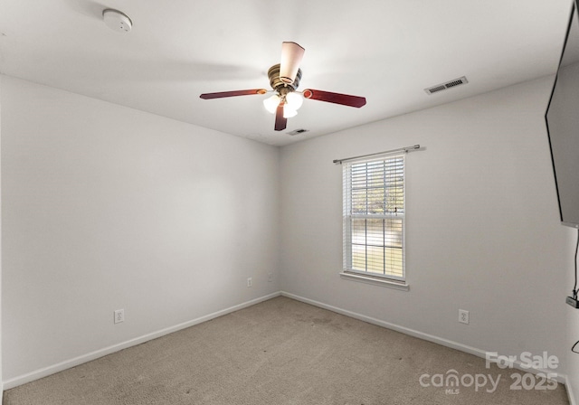 empty room featuring ceiling fan, carpet, visible vents, and baseboards