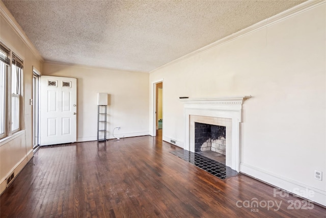 unfurnished living room with crown molding, a textured ceiling, a tiled fireplace, and wood finished floors